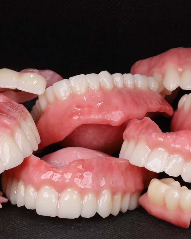 Próteses totais impressas em 3D, empilhadas após a produção